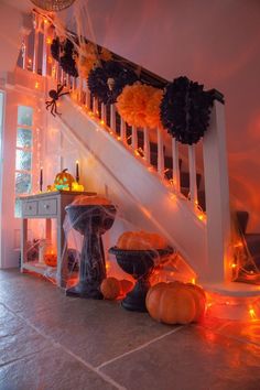 a staircase decorated for halloween with pumpkins and decorations