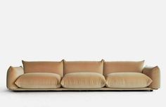 a beige couch with four pillows on the back and one arm folded out to form a rectangle shape