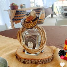 a glass bottle sitting on top of a wooden stand with a cowboy hat in it