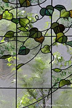 a stained glass window with green leaves on it