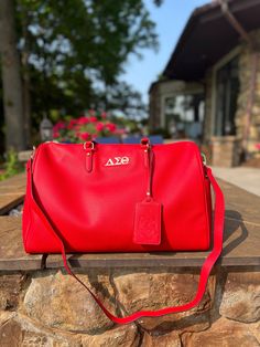 Make a statement on your next trip while keeping your belonging secure with this Carry-on Shoulder Travel Bag featuring Embossed Luggage Tag. This carry on is more than just a practical travel essential--it's a reflection of your unique style and impeccable taste. * Fully lined * Bag measures 19x13x9 Red Bags With Luggage Sleeve For Everyday Use, Rectangular Red Bags For Business Trips, Red Rectangular Bags For Business Trips, Red Duffle Bag With Luggage Sleeve, Everyday Red Duffle Bag With Luggage Sleeve, Luxury Red Travel Bag For Everyday Use, Red Travel Bag With Luggage Sleeve, Red Travel Bag With Luggage Sleeve For Daily Use, Everyday Red Rectangular Travel Bag