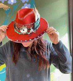 Such a fun hat- burnt orange color, polyester fabric, western style accents, beads and turquoise pops. Toped off with scrap bandana and turquoise chunk pieces around the rim. Accented with silver distressing  one size fits most. Western Red Hat Bands For Winter, Red Western Hat Bands For Winter, Western Style Red Hat Bands For Winter, Western Red Fedora Felt Hat, Red Western Fedora Felt Hat, Western Style Red Fedora Felt Hat, Red Western Style Fedora Felt Hat, Red Fedora Hat For Festivals, Adjustable Red Felt Hat For Western-themed Events