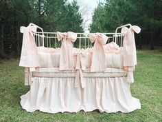 a crib with pink ruffles and bows on it