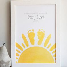 a white frame with a yellow hand and foot print on it next to a pear