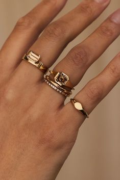 a woman's hand with three different rings on it