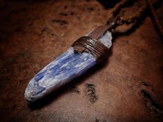 This stone is wrapped with waxed cotton cord and up-cycled leather and comes with an adjustable brown cord. The stone is an awesomely coloured blue Kyanite crystal. The pendant is made to be reversible with no visible knots, you can see both sides of the pendant in the photographs.  The pendant comes on a hand woven necklace. The length of the necklace is adjustable using a sliding wooden bead. This piece of Kyanite measures; 60mm x 17mm x 11mm ~ Blue Kyanite Crystal, Kyanite Crystal, Woven Necklace, Blue Kyanite, Style Necklace, Cotton Cord, Waxed Cotton, Crystal Pendant, Wooden Beads