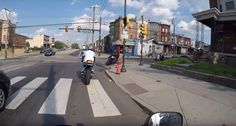 a man riding a motorcycle down a street next to traffic lights