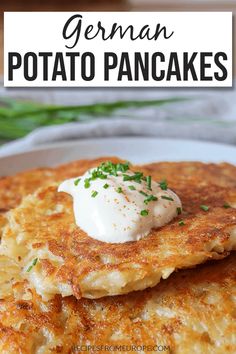 a stack of german potato pancakes on a white plate with sour cream and chives