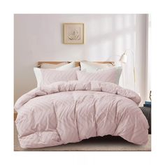 a bed with pink comforter and pillows in a room