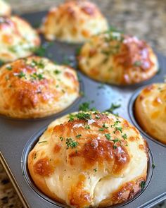 several muffins with cheese and herbs in a muffin tin