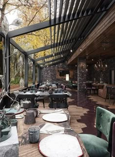 an outdoor dining area with tables, chairs and plates on the wooden floored patio