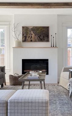 a living room filled with furniture and a fire place in front of a painting on the wall