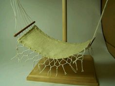 a white hammock is sitting on a wooden stand