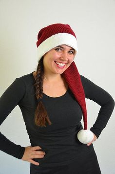 a woman wearing a red and white knitted hat with a pom - pom