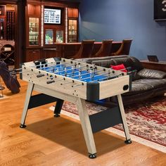 a foosball table sitting on top of a hard wood floor in a living room