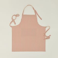 an orange and white striped apron with two ties on the front, one is tied up