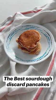 the best sourdough discard pancakes on a white plate with pink and blue stripes