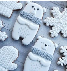 decorated cookies are arranged on a table with snowflakes and teddy bears in the background