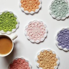 crocheted coasters with coffee cup and saucer next to them on a white surface