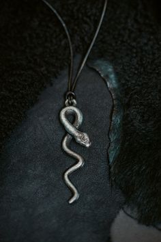 Introducing the exquisite Lilith Goddess Snake Pendant, a captivating piece of jewelry that beautifully combines mythology and craftsmanship. This unique pendant is a stunning homage to the enigmatic figure of Lilith, intricately designed to reflect her symbolic power and allure. Crafted from nickel patina, this pendant features a meticulously detailed snake, elegantly coiled and poised for action. The snake, a potent symbol of transformation and wisdom, embodies the essence of Lilith herself. I Spiritual Metal Jewelry In Snake Shape, Spiritual Snake-shaped Metal Jewelry, Symbolic Snake-shaped Brass Jewelry, Engraved Metal Snake-shaped Jewelry, Bronze Snake-shaped Jewelry Gift, Bronze Snake-shaped Jewelry For Gift, Bronze Snake Shape Jewelry As Gift, Medieval Style Metal Engraved Necklaces, Spiritual Snake-shaped Engraved Jewelry