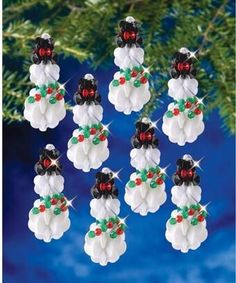 twelve snowmen are hanging from a christmas tree ornament with red, white and green beads