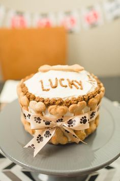 there is a cake that says lucky on top of the cake with paw prints around it