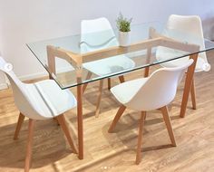 a glass table with white chairs around it