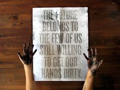 two hands reaching up towards a sign that reads, the future belongs to the few of us still writing to get our hands dirty