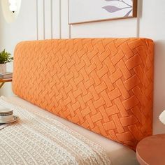 a bed with an orange headboard sitting on top of it