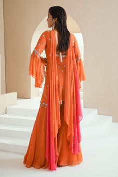 Orange peplum kurta with floral embellishments in pearls, glass beads and white beads. Comes with gharara and ombre dupatta.
Components:3
Pattern:Embellished
Type of Work:Floral Motifs
Neckline:V-Neck
Sleeve Type:Umbrella Sleeves
Fabric:Kurta: Georgette, Gharara: Organza and Crepe, Dupatta: Chiffon, Lining: Satin
Color:Orange
Other Details:
Asymmetric kurta
Back cut-out with tassel tie-up
Ombre dupatta
Occasion:Sangeet - Aza Fashions Eid Floor-length Sharara With Dupatta, Long Choli With Dupatta In Georgette, Long Georgette Palazzo Set With Sheer Dupatta, Long Palazzo Set With Sheer Dupatta In Georgette, Navratri Sharara With Dabka Work And Traditional Drape, Semi-stitched Long Sharara For Designer Wear, Eid Georgette Sharara With Cutdana, Eid Sharara With Cutdana On Georgette, Eid Sharara In Georgette With Cutdana