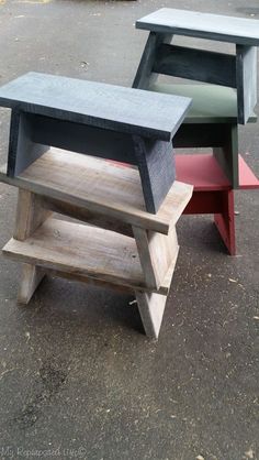 three wooden benches sitting on top of each other in the middle of a parking lot