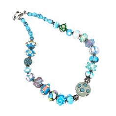 This exquisite necklace features a stunning array of handcrafted lampwork beads, each uniquely designed with vibrant blue and green accents. The beads range in size and design, creating a visually captivating piece. With a secure toggle clasp, this necklace is both stylish and functional. It's a perfect statement piece that adds a touch of artistry and elegance to any outfit. * Handcrafted lampwork beads * Blue and green accents * Secure toggle clasp * Unique bead designs * Vibrant and eye-catch Blue Artisan Jewelry With Colorful Beads, Artisan Blue Jewelry With Colorful Beads, Artisan Blue Jewelry With Large Beads, Blue Artisan Necklace With Large Beads, Artisan Blue Necklace With Large Beads, Turquoise Glass Necklaces With Large Beads, Handmade Blue-green Beaded Necklaces, Blue Czech Glass Necklace With Large Beads, Artisan Blue Beaded Jewelry