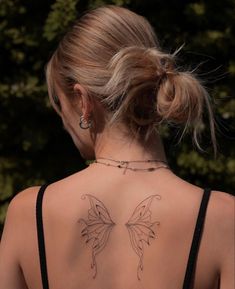 a woman with a butterfly tattoo on her back