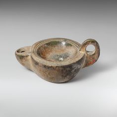 an old, dirty looking bowl with two handles on the bottom and one in the middle