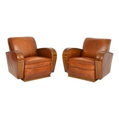 two brown leather chairs sitting next to each other