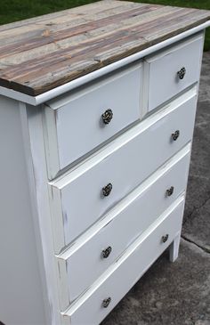 a white dresser with wooden top and drawers