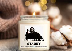 a candle that says i'm feeling stabby on it next to cotton balls