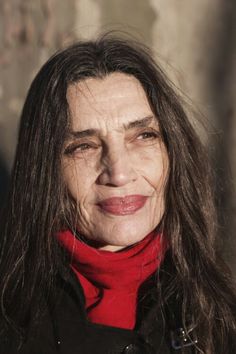 an older woman with long hair wearing a red scarf