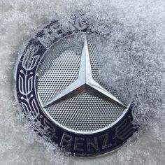 the mercedes emblem is covered in snow