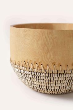 a wooden bowl with some pins sticking out of the inside of it, sitting on a white surface