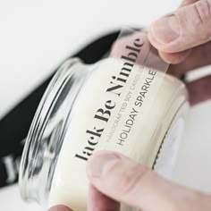 a person is holding a jar with some liquid in it and the bottle has a label on it