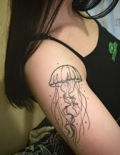 a woman's arm with a jellyfish tattoo on her left shoulder and right arm