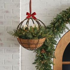 two christmas decorations hanging from the side of a brick wall next to a wreath and door