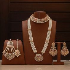 Giving out an elegant vibe owing to its sparking stone mix! A versatile set encrusted with Navratan stones and pearl moti. The set includes a pair of beautiful earrings, jhoomar, tika, necklace and mala. Gold-plated on high-quality brass as base metal. Approximate earrings length is 3.5″. Luxury 22k Gold Bridal Necklace With Stone Work, Luxury Gold Plated Bridal Earrings With Meenakari, Luxury Meenakari Temple Jewelry Pearl Earrings, Traditional Pearl Jewelry Sets For Reception, Traditional White Pearl Set, Festive White Pearl Sets, Pearl Chandbali Sets With Stone Work, White Pearl Chandbali Bridal Sets, Bollywood Style Pearl Sets With Stone Work