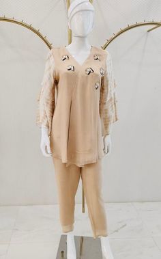 A peach colored kurta and palazzo set, curated for a casual evening affair, is fashioned from luxurious fabric to guarantee comfort. The short kurti, adorned with embroidered buttis scattered around the neck and featuring elbow-length 3 tier sleeves, exudes an understated elegance. The ensemble is impeccably completed by plain straight pants in matching colors, presenting a cohesive and sophisticated look.  Note: Colors may slightly vary due to photographic lighting. Please contact us if you hav Peach Kurti, Kurta And Palazzo, Short Kurti, Kurta Design, Kurti Set, Palazzo Set, Casual Evening, Luxurious Fabric, Matching Colors