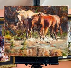 two horses standing next to each other on a easel