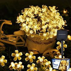 a basket full of yellow flowers next to some lights