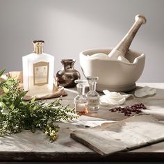 an assortment of essentials on a table with flowers and bottles in the background,