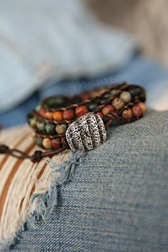 "Matte Stone Beaded Leather Wrap Bracelet: Our exclusive NEW boho wrap bracelet is created from dark brown leather and genuine 6mm Picasso jasper natural stone beads in desert landscape shades that are matte instead of shiny for a modern boho chic look. So intriguing and totally different. The end is finished with a rustic shell fragment button clasp replicated in sterling silver that can be fastened into 1 of 3 loops for adjustability to FIT WRISTS ranging from 5 3/4\"-7\" (14.6cm - 18cm). This Rustic Hand-wrapped Bracelet With Round Beads, Hippie Wrap Bracelet With Round Beads For Festivals, Hippie Adjustable Wrap Bracelet With Round Beads, Hippie Wrap Bracelet With Round Beads, Adjustable Hippie Wrap Bracelet With Round Beads, Hippie Style Adjustable Wrap Bracelet With Round Beads, Hippie Style Wrap Bracelet With Round Beads For Festivals, Bohemian Bracelets With 108 Beads For Jewelry Making, Bohemian Adjustable Wrap Bracelet With Round Beads