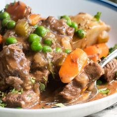 a white bowl filled with meat and vegetables